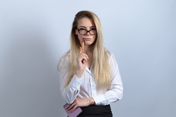 a young woman student Intern trainee reporter in glasses and a business suit posing looking at the camera with a thoughtful puzzled expression on white background.