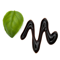 Balsamic vinegar cream and basil leaves isolated on white background. Italian salad dressing, sauce.