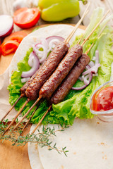 Fast food. Eastern food. Shish kebab, lyulya-kebab, shaverma, pita gyros. Dishes of oriental cuisine lying on pita bread and decorated with greens and vegetables, sauces and French fries. 