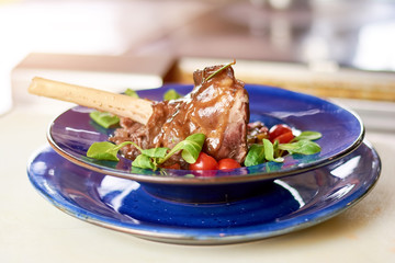 Meltingly tender meat with fresh vegetables. Slow cooked lamb shank with sauce and vegetables ratatouille. Delicious dish of european cuisine.