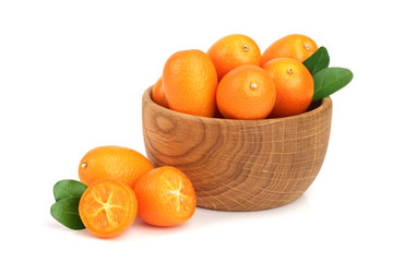 Cumquat or kumquat with leaf in wooden bowl isolated on white background close up