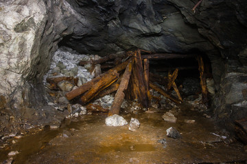 Fototapeta premium Old abandoned underground mica ore mine shaft tunnel with wooden stands