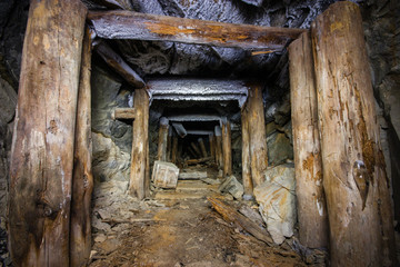 Fototapeta na wymiar Old abandoned underground mica ore mine shaft tunnel with wooden stands