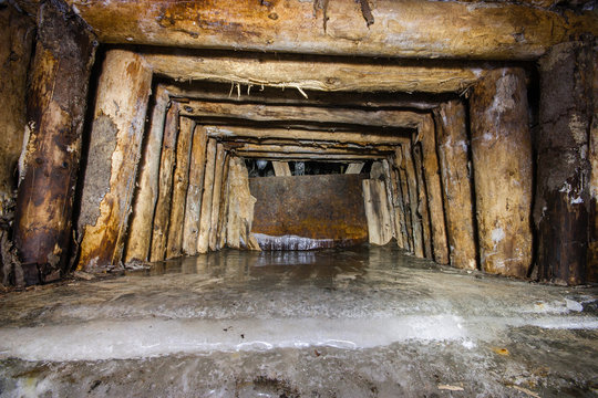 Old abandoned underground mica ore mine shaft tunnel with ice frost
