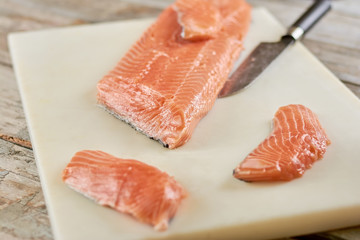 Sliced fresh salmon on cutting board. Raw salmon fillet on white cutting board.