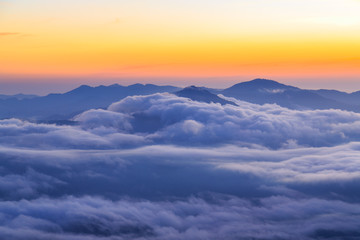 Clouds rolling over the mountains tops at sunrise