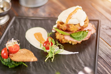 Delicious benedict for real gourmet. Beautifully served benedict on black tray in restaurant.