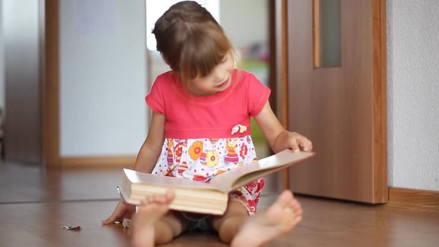 Little girl reading a big book