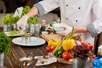 The process of cooking food at kitchen. Chef preparing food from fresh vegetables. Cook at work, restaurant.