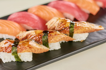 Delicious sushi with eel on plate. Sushi nigiri with eel, salmon and tuna close up.
