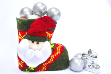 Red and green Santa's boot on the white background with Christmas white brilliant  balls. Decoration of Santa Claus background. Copy space. Concept of Xmas and new year holidays.