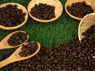Fototapeta premium Cup of coffee and coffee beans on wooden spoon and and biscuit on grass green background