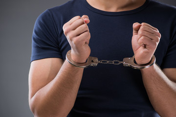 Man with his hands handcuffed in criminal concept