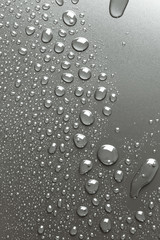 Metal surface with drops of water, silvery background