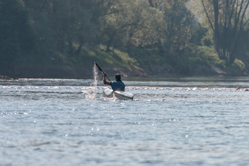 Naklejka premium atleta che se allena con la canoa, un uomo che gareggia kayak sul fiume adige, verona pescantina