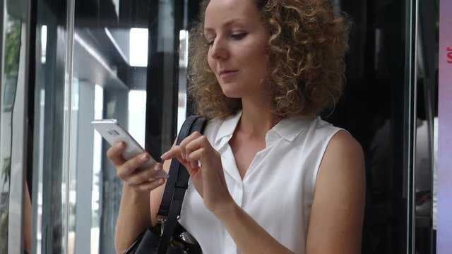Business Woman Using Smartphone In Elevator. 4K. 