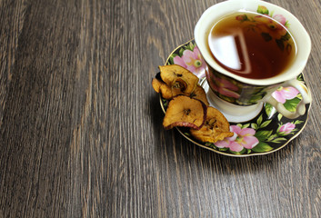A Cup of hot tea with dried fruits on a wooden table