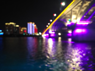 blurred bokeh lights of a city with buildings and bridge