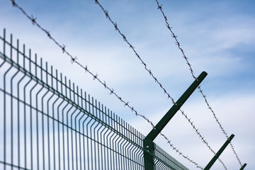 Silhouette of Barbed Wire fence against a Sky