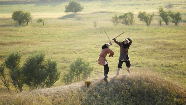Two warriors Viking are fighting with swords.