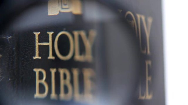 Looking for holy bible on sunday readings with magnifying glass. Concept of wisdom, religion, reading, imagination