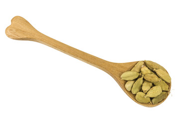 cardamom pods on a wooden spoon