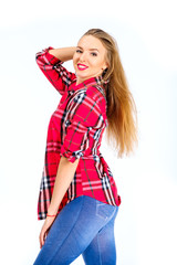 Young sexy woman dressed in jeans and checkered shirt posing in studio isolated on white