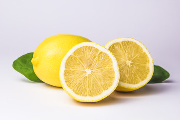 Lemon, cut into two parts, and a whole on a white background.