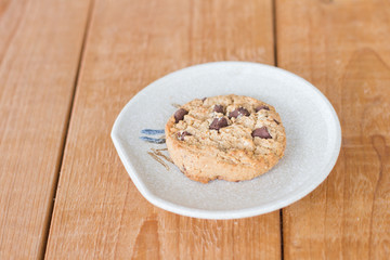 Chocolate chip cookie on a plate on a wooden table