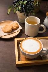 Cookies, tea, and coffee on a dark wooden table