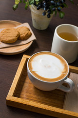 Cookies, tea, and coffee on a dark wooden table