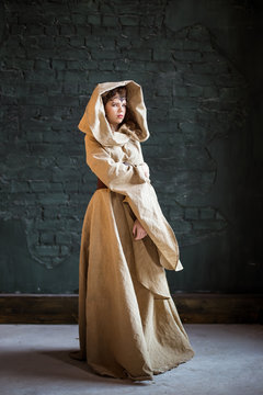 Ethnic Medieval Image Of A Witch, Elf. A Dress Made Of Natural Fabric With A Hood. Girl, Woman From A Fairy Tale, Fantasy.