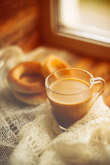 Hot chocolate in mug with marshmallows, wrapped in a woollen scarf