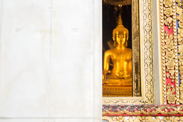 The main Buddha statue looking through the window of Wat Bowonniwet Vihara temple, Bangkok, Thailand