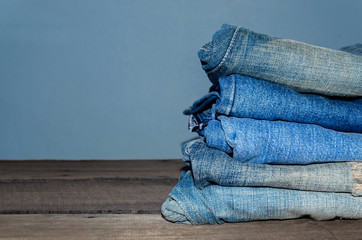 Blue jean and jean lack texture on the wooden floor, Pattern of blue jeans are overlapping on the table.