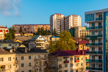 Fototapeta na wymiar View of apartment buildings on the mountain in the in light of the setting sun, Sochi, Russia