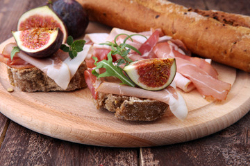 Sandwich with figs and prosciutto. Antipasti gourmet bruschetta snack.