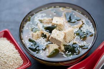 Closeup of asian traditional miso soup with wakame, tofu and sesame seeds, selective focus