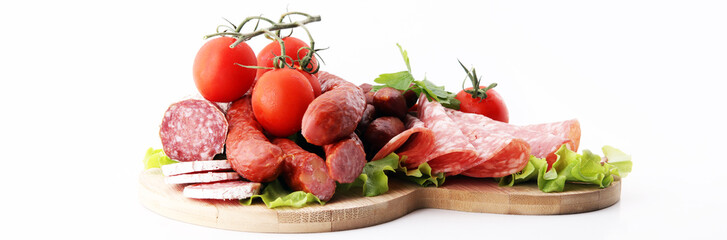 Food tray with delicious salami, pieces of sliced ham, sausage, tomatoes, salad and vegetable - Meat platter with selection - Cutting sausage and cured meat