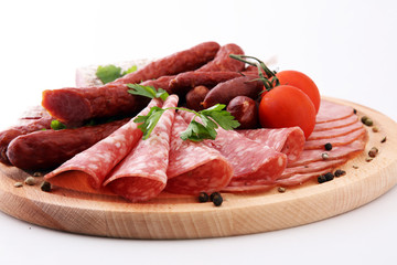 Food tray with delicious salami, pieces of sliced ham, sausage, tomatoes, salad and vegetable - Meat platter with selection - Cutting sausage and cured meat