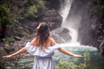 the girl looks at the waterfall back