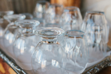 Clean glass goblets are turned upside down and stand on tray in cafe