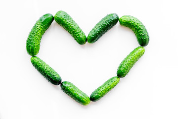 Fresh cucumbers in shape of heart on white background top view mockup
