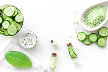 Obraz na płótnie Canvas Fresh organic cosmetics with cucumber. Cream, lotion, spa salt on white background top view copyspace