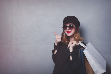 Style redhead girl in hat with shopping bags and sunglasses