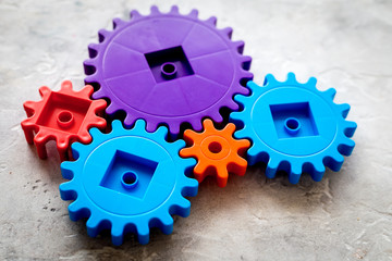 moving forward concept, ideal operating principle with gears and wheels on stone background