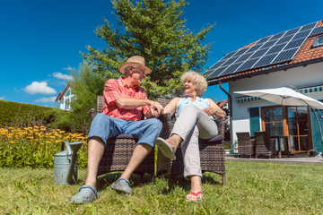 Glückliche Frau und Mann, ein Senioren Paar, entspannt im Garten vor dem Haus
