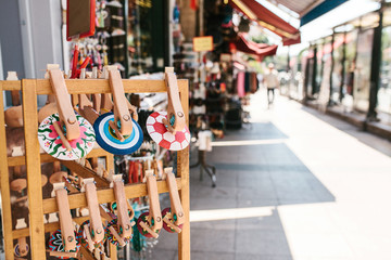 Wooden souvenirs on the street against the background of blurry street stalls and shops