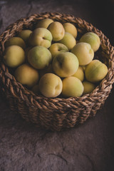 Pile of vineyard peach in wooden basket on stone surface 