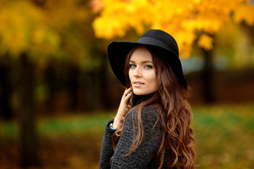 Portrait of very beautiful young girl in autumn park